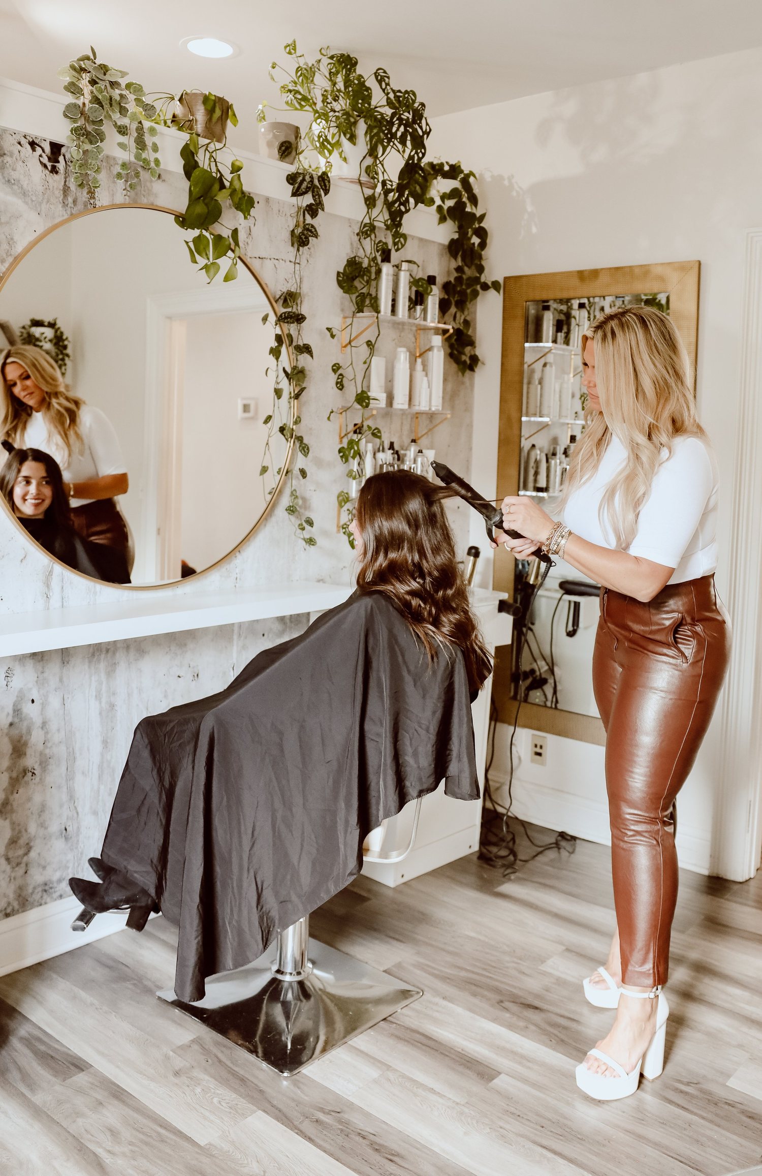A Sweet Melissa stylist curling a client's extensions at the mirror